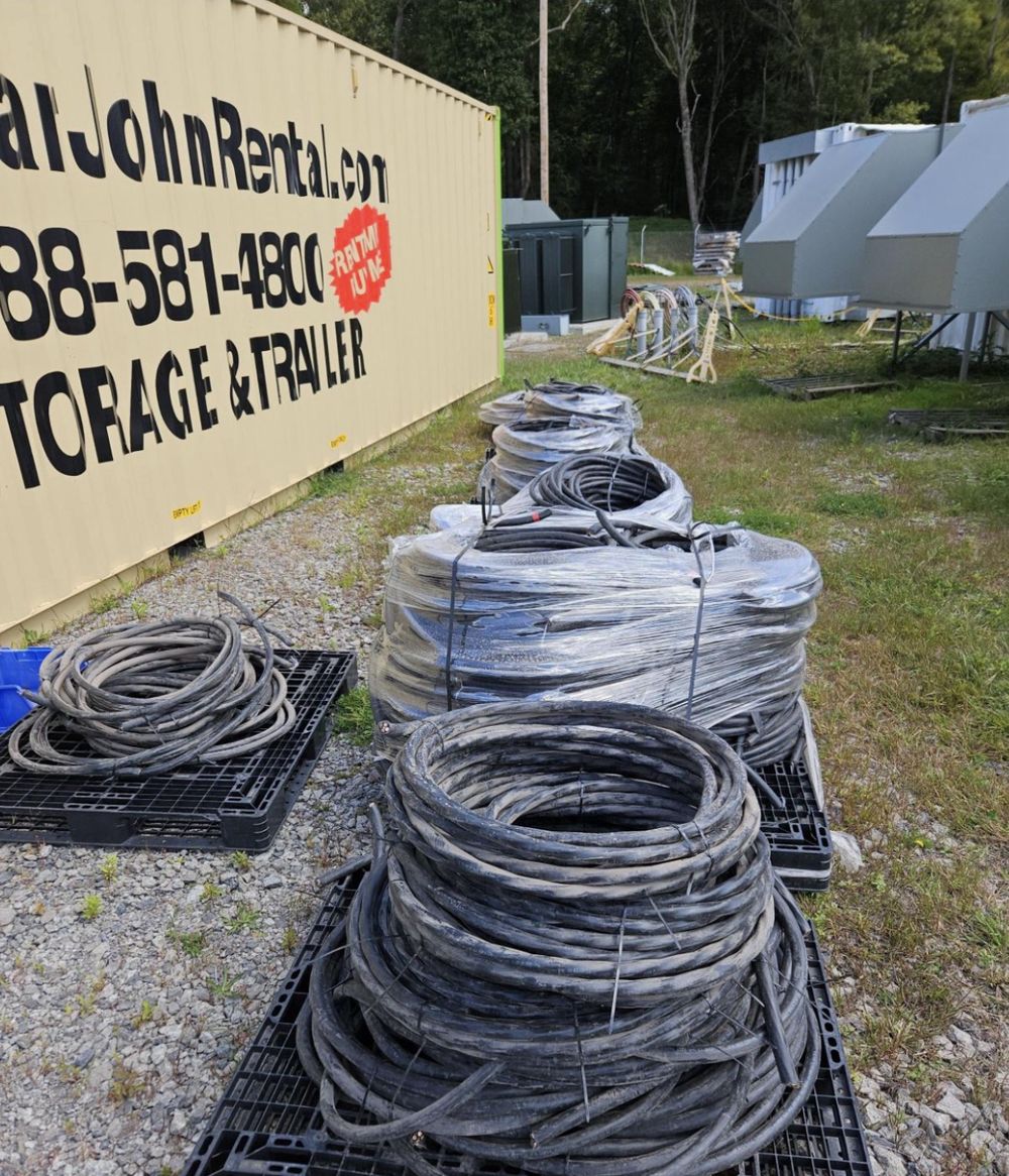 Coils of surplus building wire strapped to pallets in a staging yard